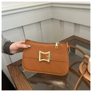 Gros plan sur la texture en cuir matelassé marron et la boucle rectangulaire dorée