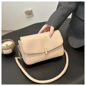 Nahaufnahme einer eleganten beigen Ledertasche mit goldenem Metall-Druckverschluss-Detail