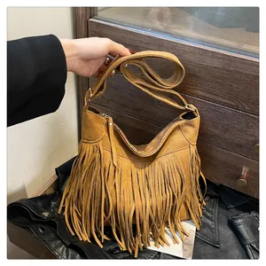 Dettaglio della trama in pelle scamosciata e lunghe nappe boho sfrangiate sulla borsa