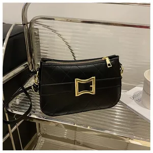 Détail d'un sac bandoulière noir matelassé avec un fermoir carré doré et texture