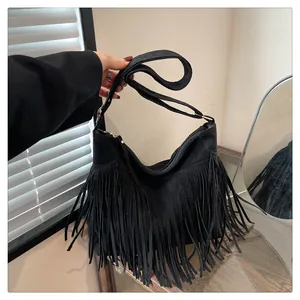 Dettaglio della borsa tote in pelle scamosciata nera con lunghe frange e finitura opaca