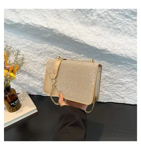 Detailaufnahme der glitzernden champagnergoldenen Abendtasche mit edler Metallkette