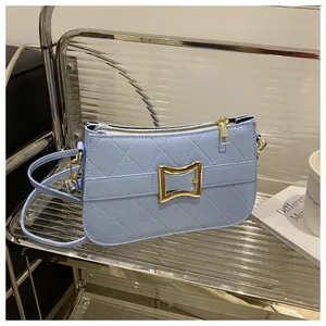 Gros plan sur le sac bandoulière matelassé bleu clair avec boucle carrée dorée de luxe