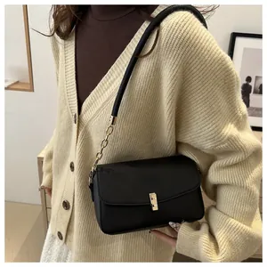 Detailansicht der minimalistischen schwarzen matten Umhängetasche mit goldener Kette