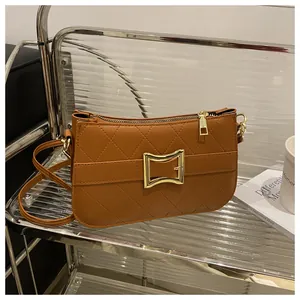 Gros plan détaillé du sac en cuir matelassé marron avec grande boucle carrée dorée