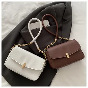Flache Ansicht von weißen und dunkelbraunen PU-Handtaschen mit Metallkette und Griffen