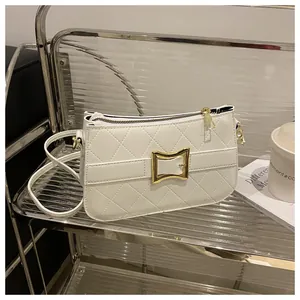 Gros plan d'un sac à main matelassé blanc avec fermoir carré doré et texture en cuir