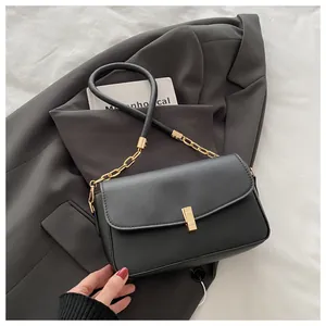Detail der schwarzen Handtasche mit goldener Kette und elegantem Metall-Drehverschluss