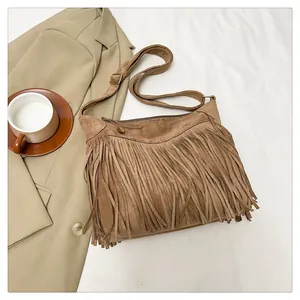 Dettaglio della borsa a spalla color cammello scuro con nappe e texture scamosciata