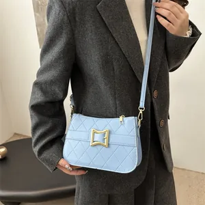 Sac bandoulière matelassé bleu clair avec fermoir doré et bandoulière sur mannequin