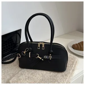Detailopname van een vintage zwarte schelptas met gouden hardware op een stijlvol bureau