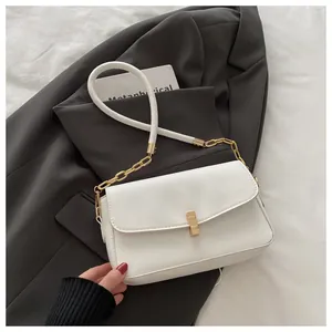 Nahaufnahme einer weißen Leder-Umhängetasche mit goldener Schnalle und eleganter Kette