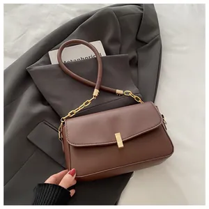 Detail der dunkelbraunen Lederhandtasche mit Goldverschluss und elegantem Kettenriemen