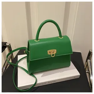 Detail der grünen Lederhandtasche mit goldenem Drehverschluss und Metallgriff