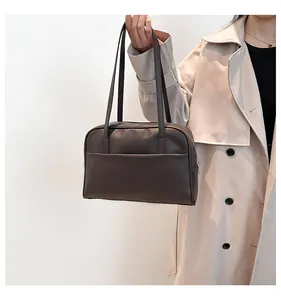 Détail d'un sac cabas marron foncé minimaliste avec bandoulières en cuir mat