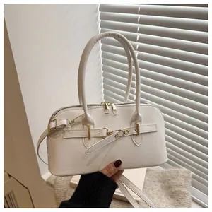 Detail van witte PU-schelptas met dubbele ritsen en luxe gouden metalen gespen