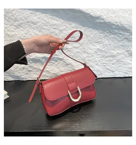 Detail of the elegant dark red flap bag featuring a polished silver U-shaped metal buckle