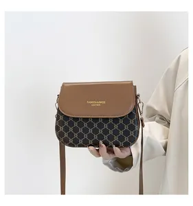 Detail of the vintage monogram pattern and gold lettering on this elegant brown crossbody bag