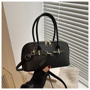 Detail van een vintage zwarte leren tas met goudkleurige gespen en handvat voor dames