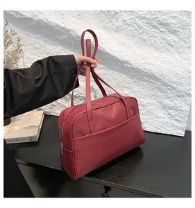 Détail d'un sac cabas en cuir synthétique rouge avec poche avant et fermeture éclair