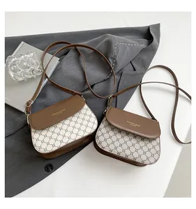 Detailed shot of retro monogram crossbody bags with gold lettering and adjustable straps