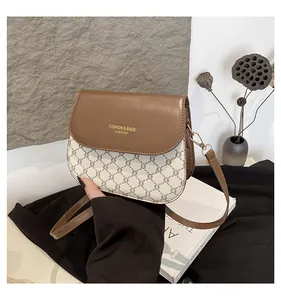 Detail of vintage crossbody bag with brown leather trim and classic monogram pattern