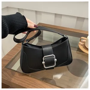 Detail of elegant black underarm bag with silver square buckle in a lifestyle setting