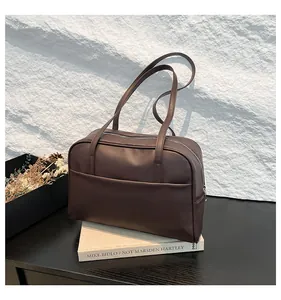 Détail d'un sac cabas vintage marron foncé avec cuir mat et fermeture éclair argent