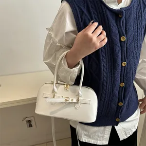 Elegante witte schelptas in glanzend leer met gouden hardware en dubbele handvatten