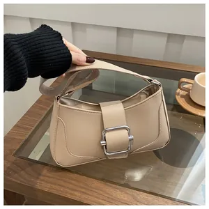 Detailed close-up of a chic beige faux leather crossbody bag with a silver square buckle
