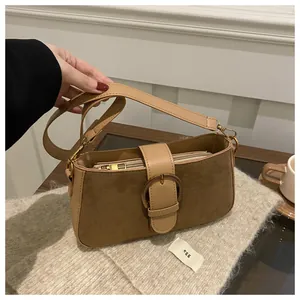 Détail du sac bandoulière vintage camel avec texture daim et boucle métal sur tissu tricoté