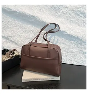 Gros plan du sac cabas marron foncé avec poche frontale et fermeture éclair argentée