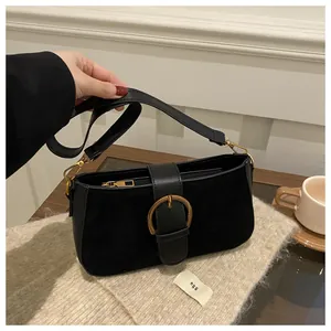 Détail du sac rétro noir avec boucle dorée en fer à cheval et texture mate élégante