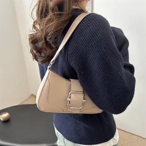 French style beige leather baguette bag with silver buckle worn by a model in profile