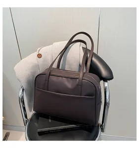 Gros plan détaillé du grand sac cabas marron foncé avec texture mate et fermeture éclair