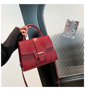Close-up of red crocodile-embossed leather texture on a stylish luxury handbag