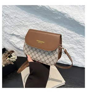 Close-up of brown leather flap with gold lettering and grey patterned monogram texture