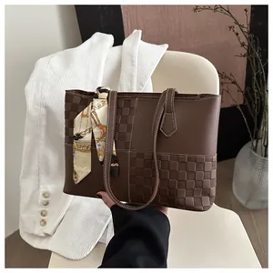 Close-up of brown tote bag with checkered texture and elegant silk scarf detail