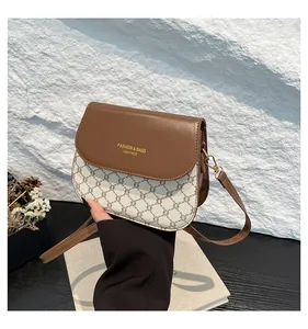 Detail of brown leather flap and logo print on contrast checked crossbody bag