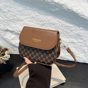 Chic vintage-style crossbody bag with brown leather contrast and elegant monogram pattern