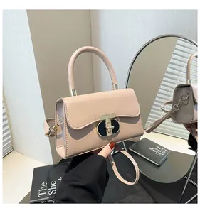 Detailed view of pale pink crossbody bag with a gold lock and circular mirror reflection