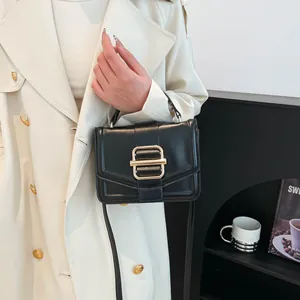 Elegant black faux leather crossbody handbag with gold lock on a chic minimal background
