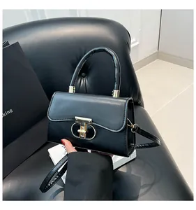 Detailed macro shot of sleek black leather handbag with elegant golden T-bar metal lock