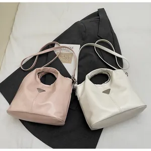 Close-up of designer tote bags with round hollow handles and triangle metal logo detail