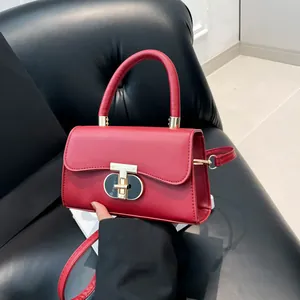 Elegant red faux leather crossbody bag with golden T-lock and structured square design