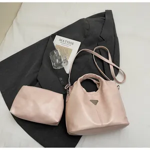 Detail view of pink tote bag and matching pouch set on grey blazer with luxury styling