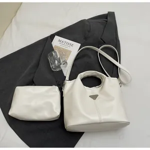 Detail view of cream white PU leather tote set with silver logo and matching pouch