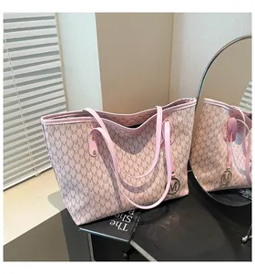 Nahaufnahme der rosa Tragetasche mit M-Muster und rundem goldenem Metallanhänger