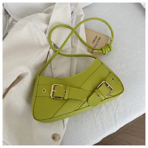Detail of fruit green PU shoulder bag featuring gold metal buckles and eyelets on book