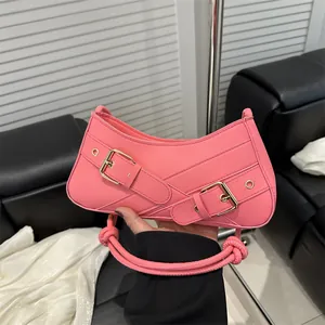 Pink Y2K style baguette shoulder bag with decorative buckle straps and knotted handle